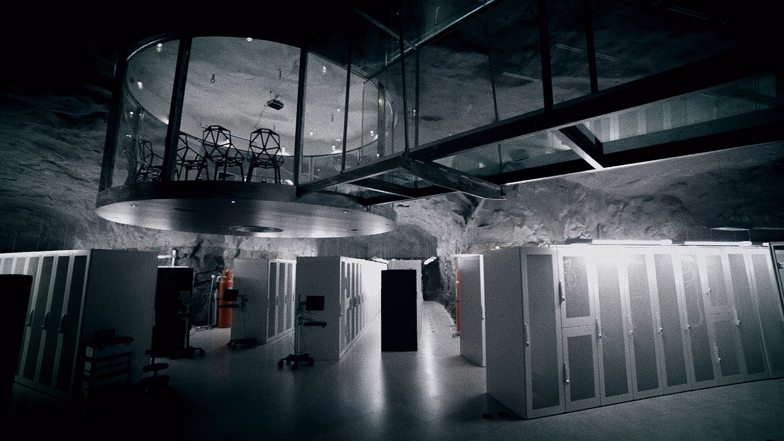 Une salle machine creusée dans la roche : des rangées de baies alignées sous une nef vitrée suspendue.